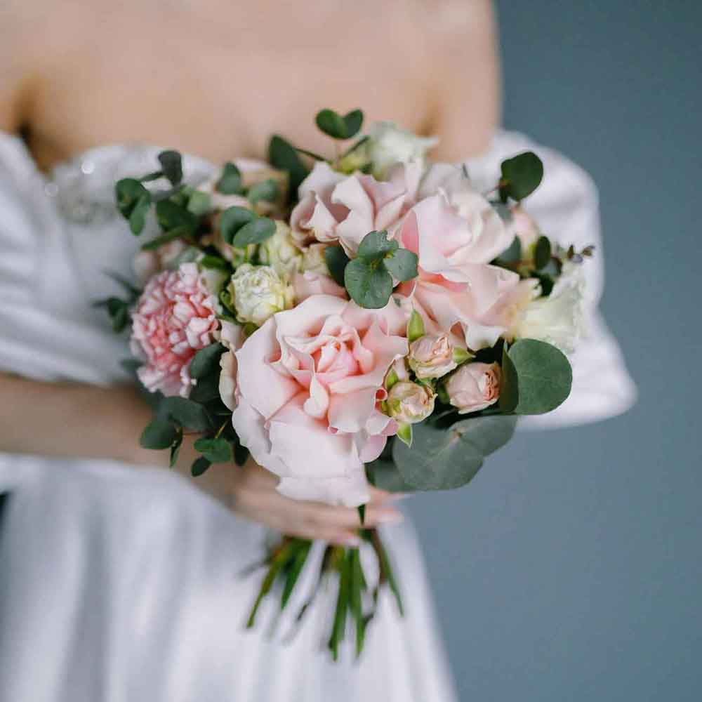 bride in white dress holding bouquet of flowers