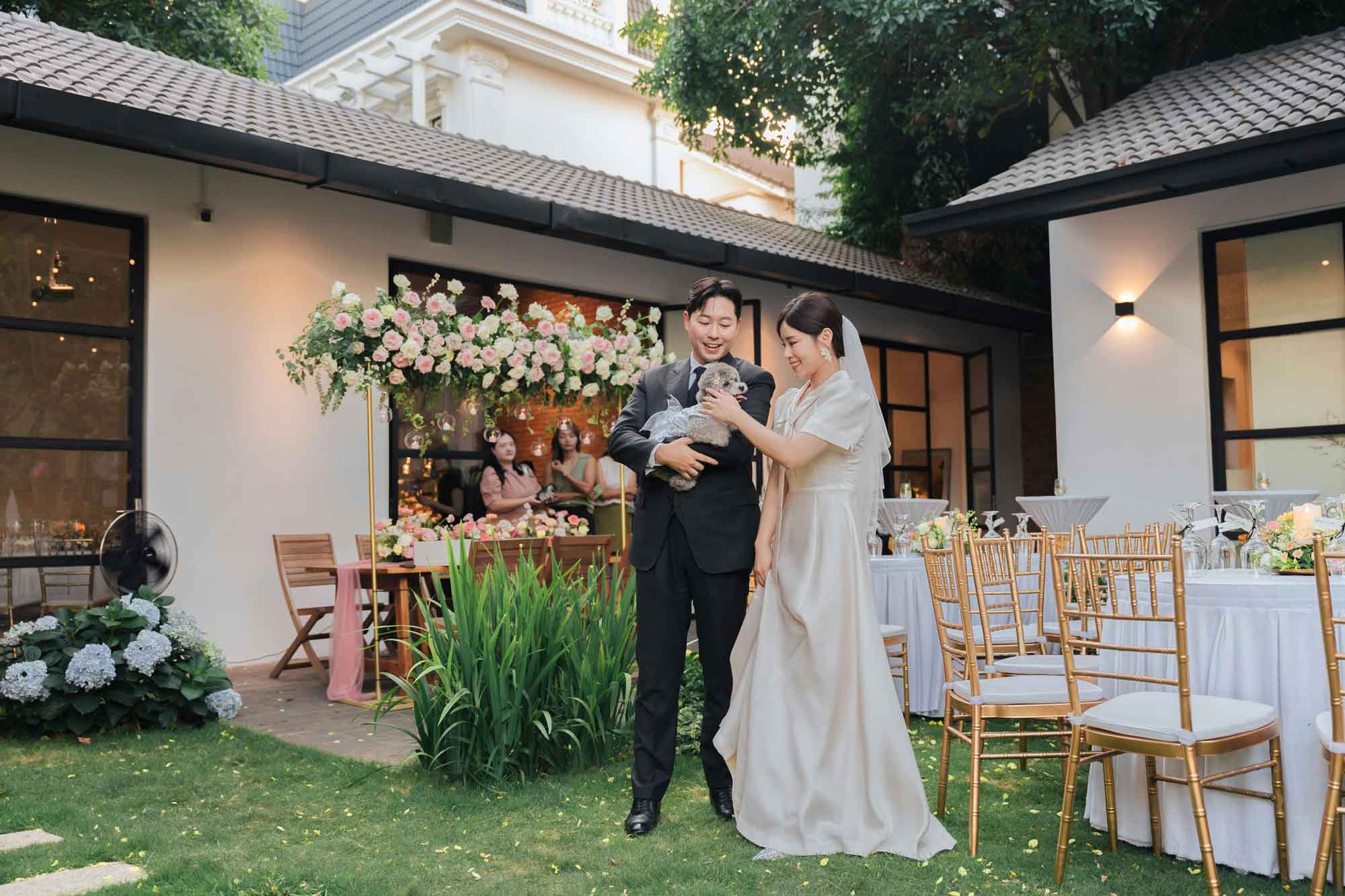 bride and groom holding dog outdoor wedding reception