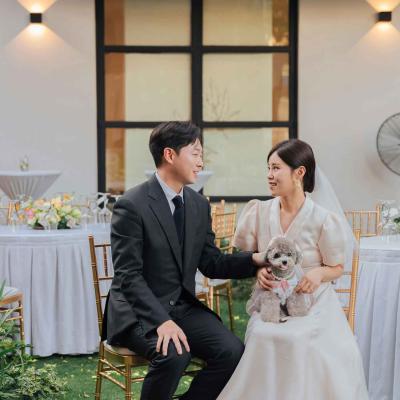 Bride and groom at wedding sitting with small dog